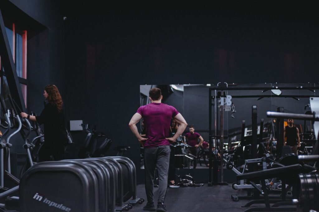 Man in a gym with fitness equipment, highlighting a healthy lifestyle.